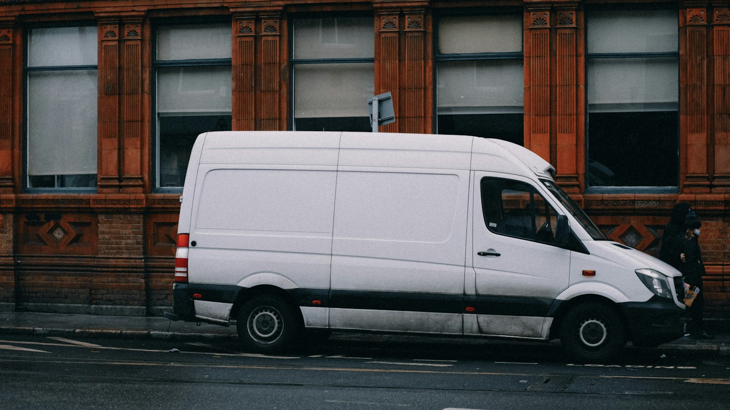 White panel van parked beside a road
